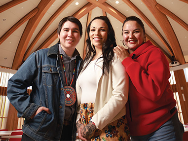 Three members of the ɫƵ Indigenous community smiling inside the Indigenous Sharing and Learning Centre 